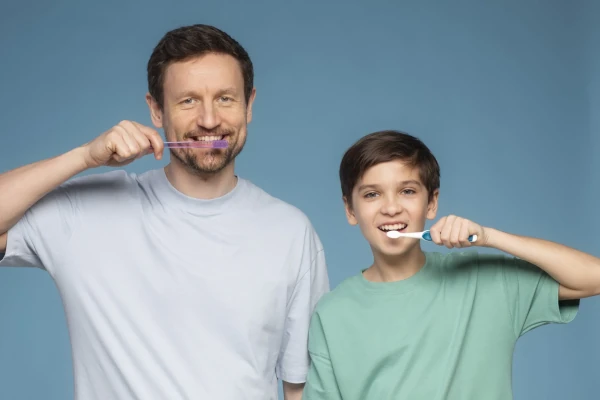 Vater und Sohn putzen die Zähne